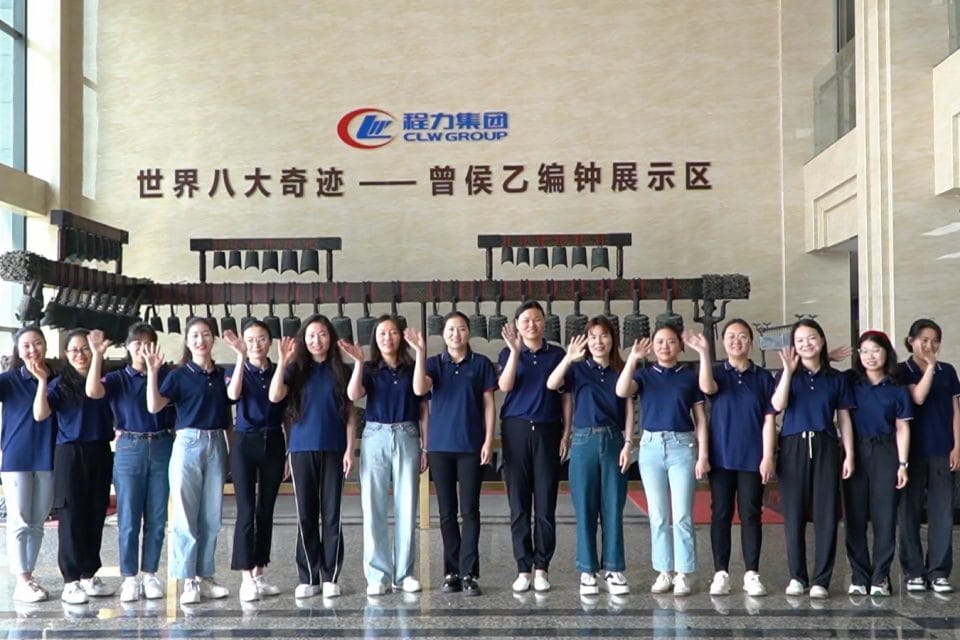 CLW Group factory staff team waving hello in showroom hall